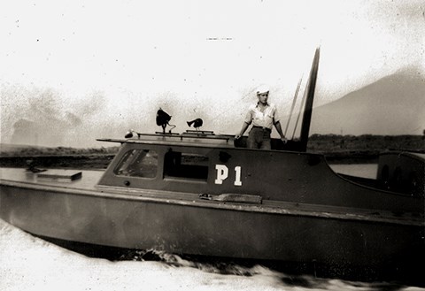 A black and white photo of Richard F. Gustafson in his military uniform on a boat.