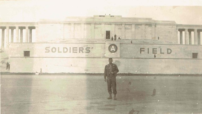 A black and white picture of a man in a uniform standing on a baseball field