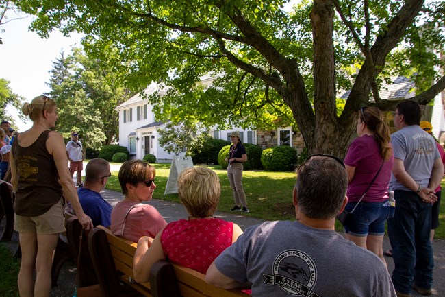 Visitors outside Eisenhower home listening to intern talking.