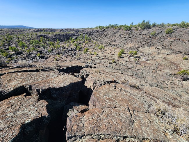 Smooth dark sheets of lava with large cracks