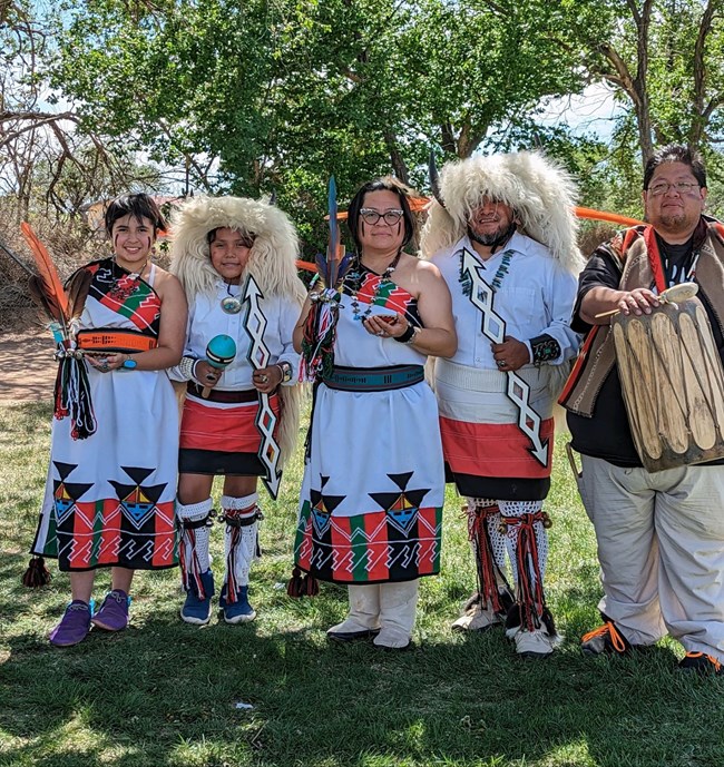Five native dancers dressed in traditional clothing