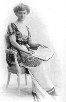 A woman sits in a chair with an open book in her lap
