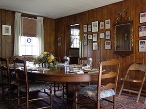 A room with wood paneled walls and an oval table with chairs.