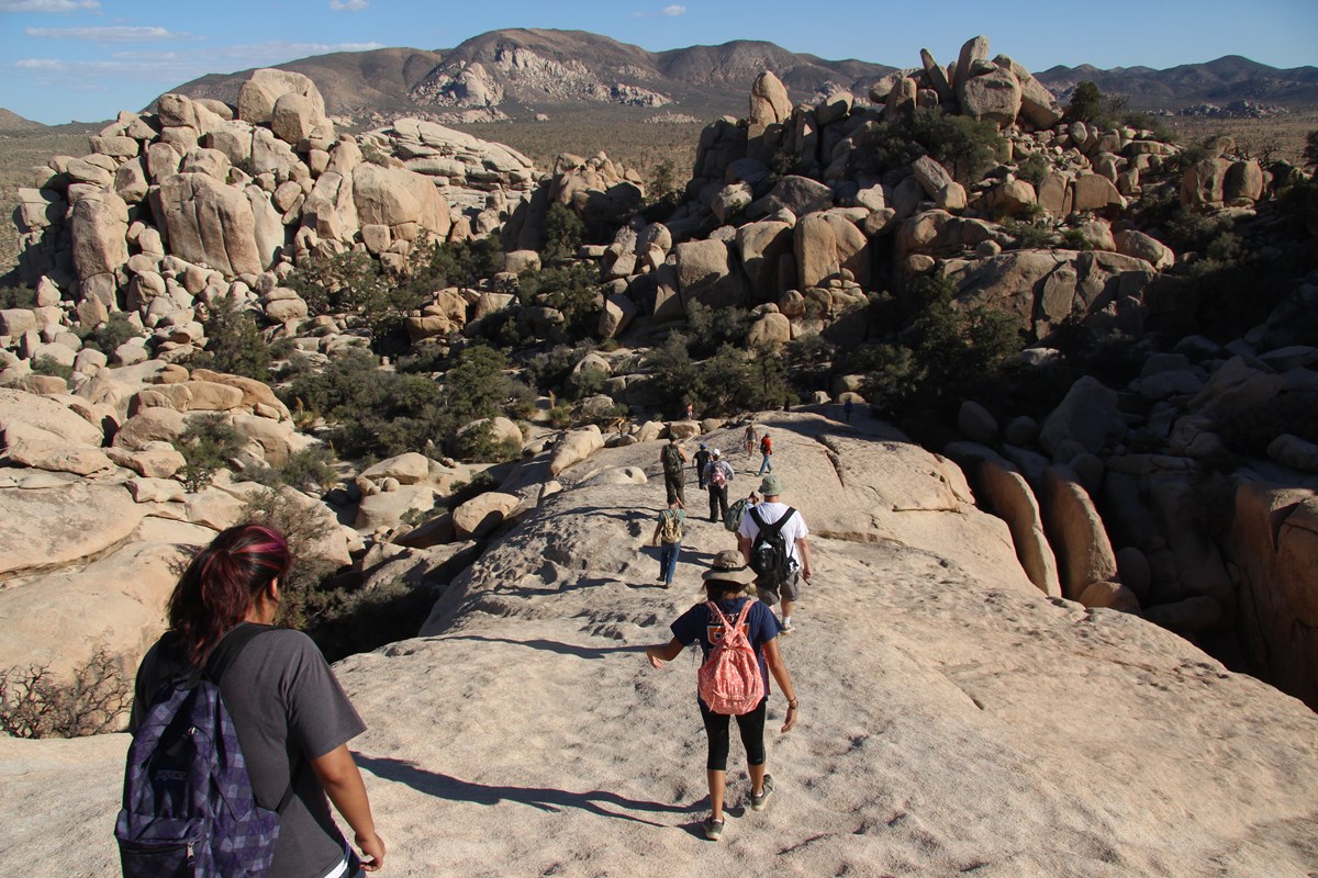 Un grupo de visitantes caminando sobre rocas en Hidden Valley