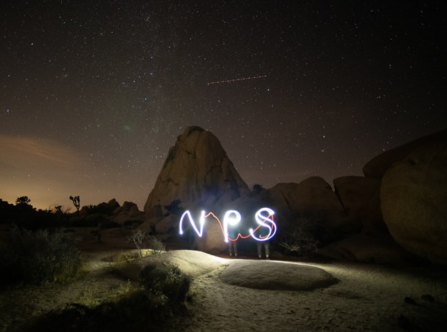 Luz escribe "NPS" delante una formacion rocosa.