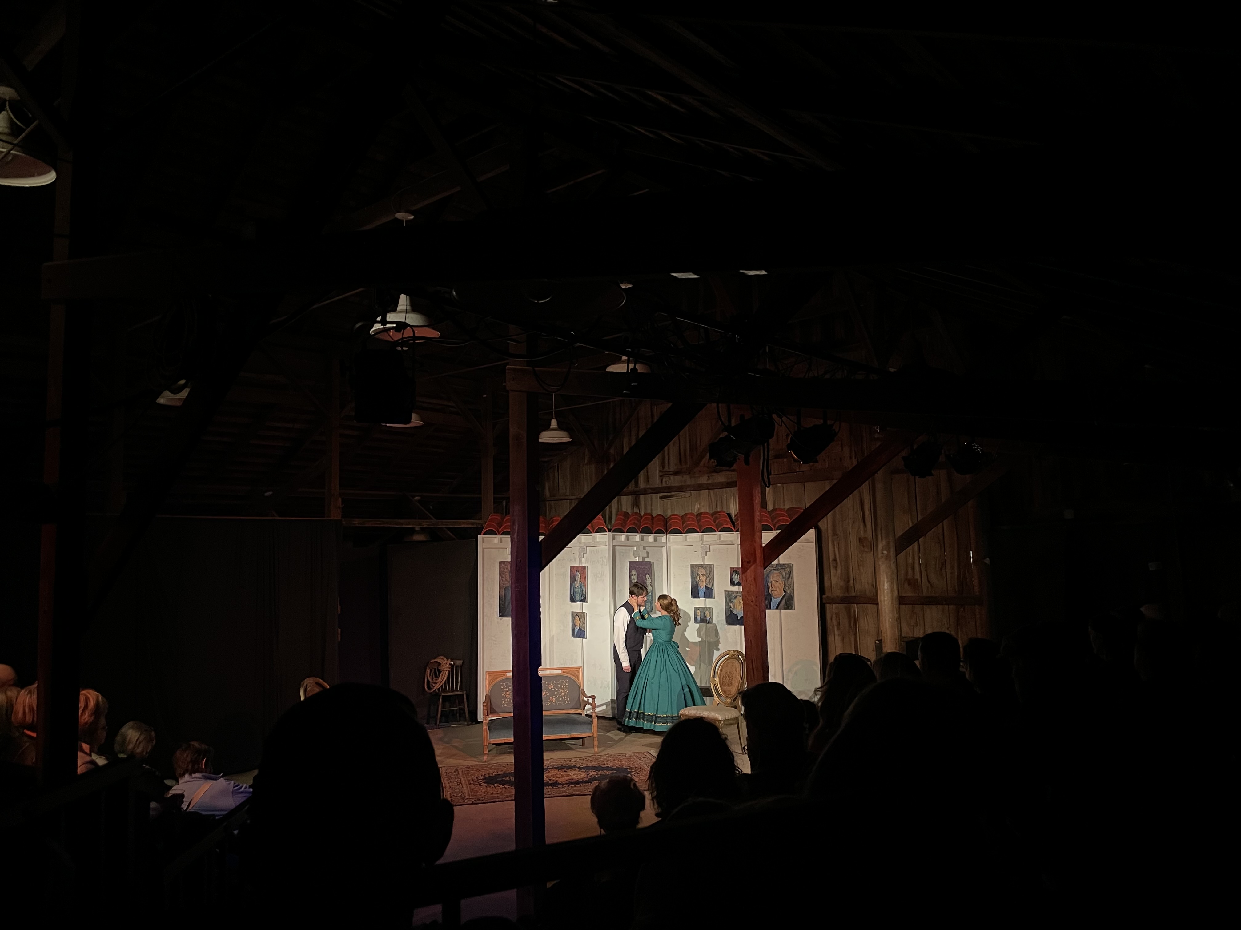 A man and a woman dressed in Civil War era clothes stand on a stage.