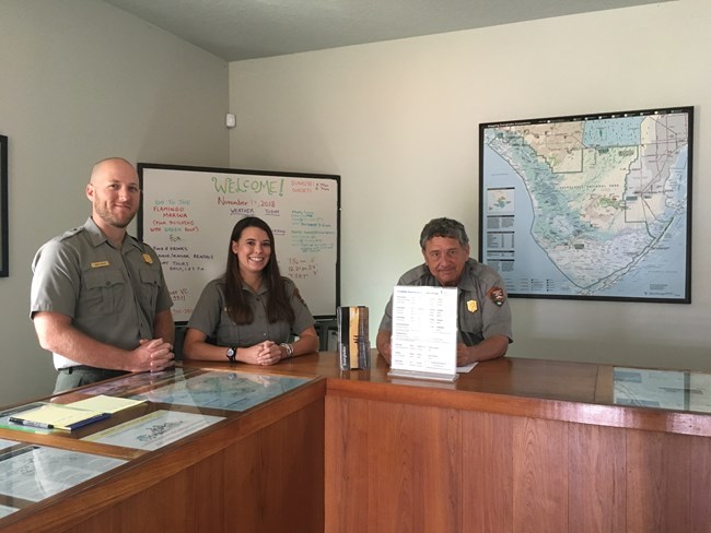 3 rangers staffing a visitor center desk