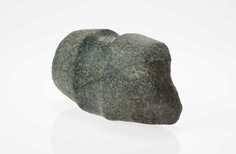 Angled view of stone with large indent in the middle.