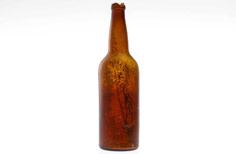 Aged brown glass bottle with chips on the top.