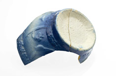 Two pieces of the bottom of blue pottery with relief patterns on it.