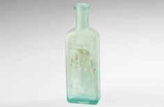 Rectangle-shaped aged aqua medicine bottle with stamped words.