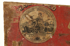 Side of aged box with red label peeling off of it.