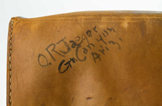 Close up view of brown camera bag with writing on it.