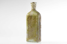 Rectangle-shaped aged dirty glass bottle with stamped wording.