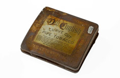 Aged metal container with label on lid.