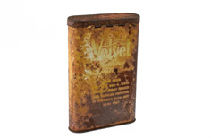 Aged metal container with label on side.
