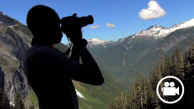Man taking photo of snow-capped mountain view