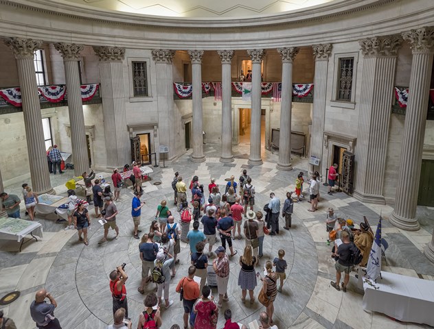 A view looking down from the 2nd story into a large lobby with many people in it.