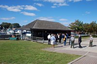 Group gathers around old ferry terminal building and podium.