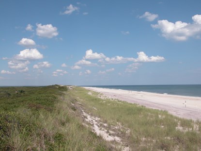 View of dune line, looking east on a clear day with puffy clouds.