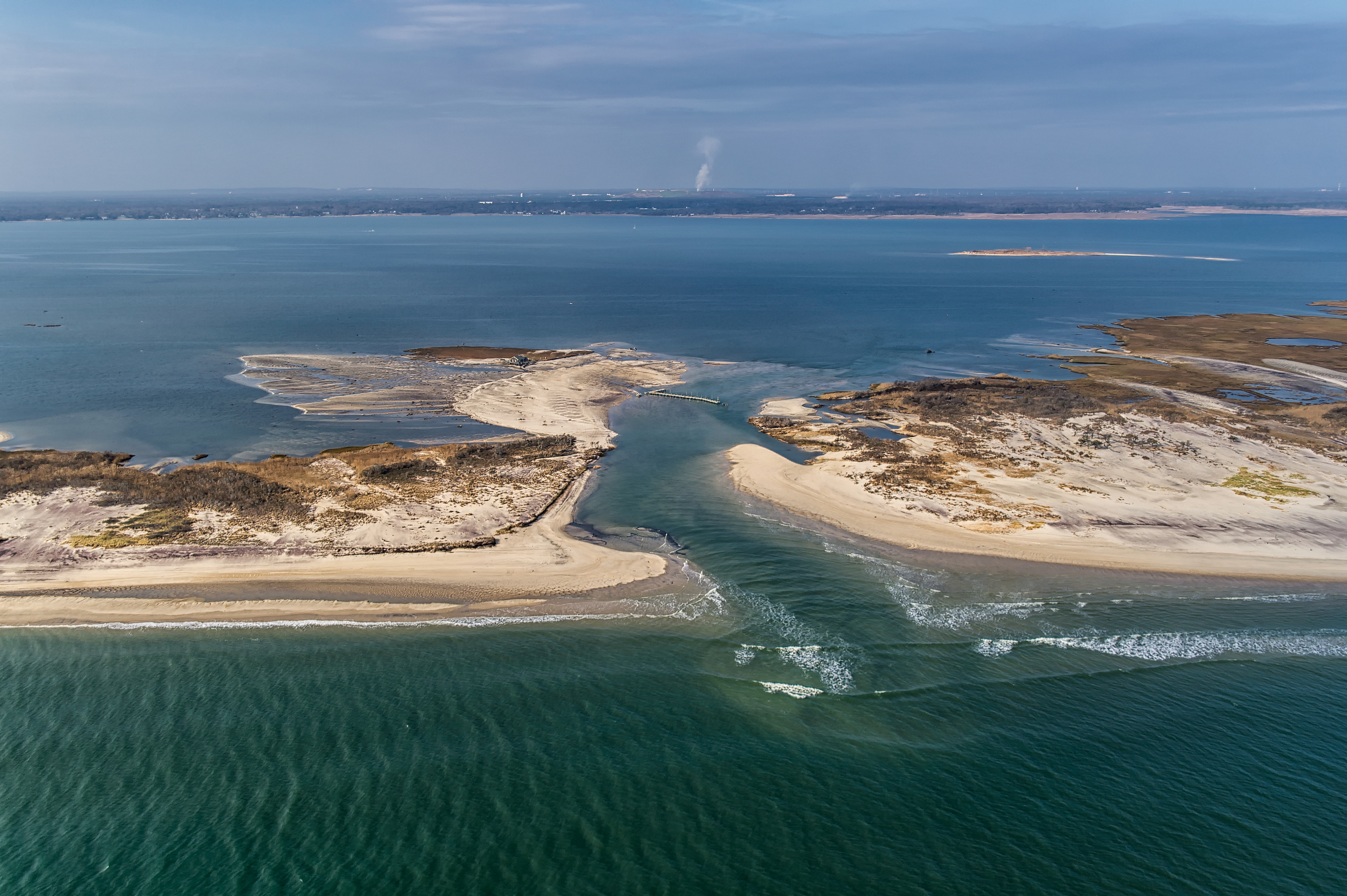 A deep channel break in a barrier island seen from above.