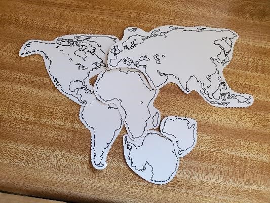 Paper cutouts of the seven continents arranged to join together as they were to create the prehistoric super continent Pangaea.