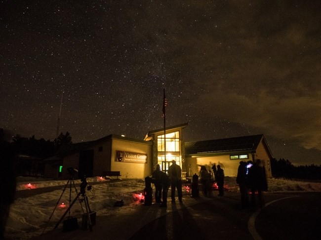 Visitors looking at the night skies through telescopes in front of the Visitor Center at Florissant Fossil Beds