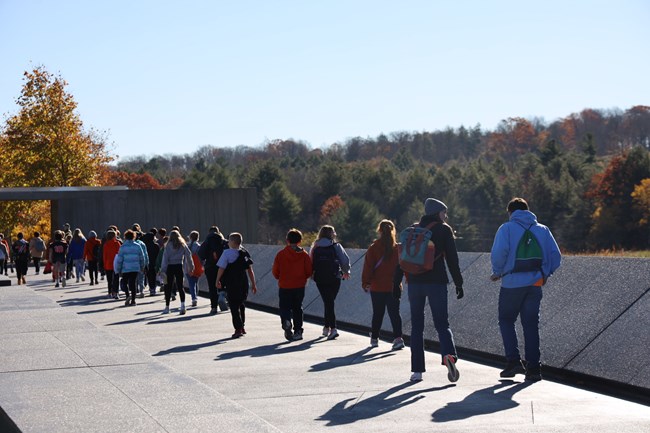A group of students walking along the Memorial Plaza