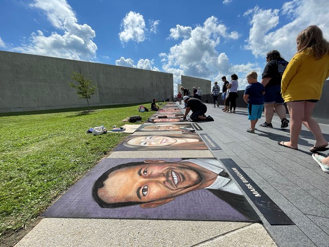 Artists with work chalk to create images of the passengers and crew.