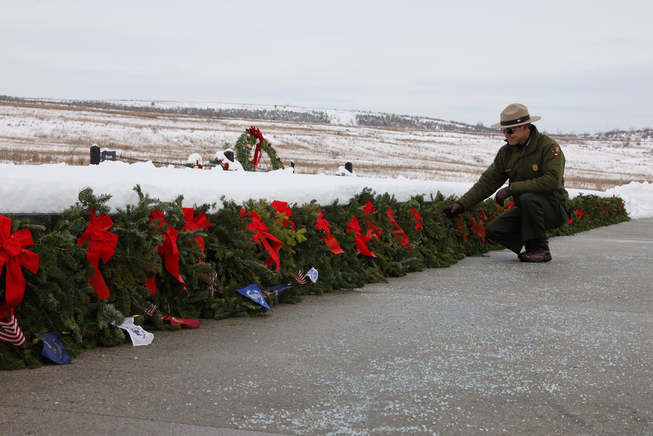 Ranger kneeling by wreaths.