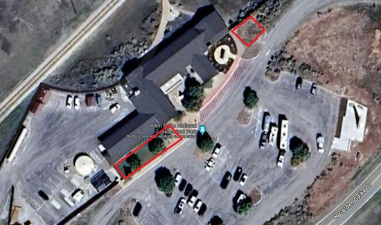 Aerial photo of building with area to the front left and another area to the right circled in red.