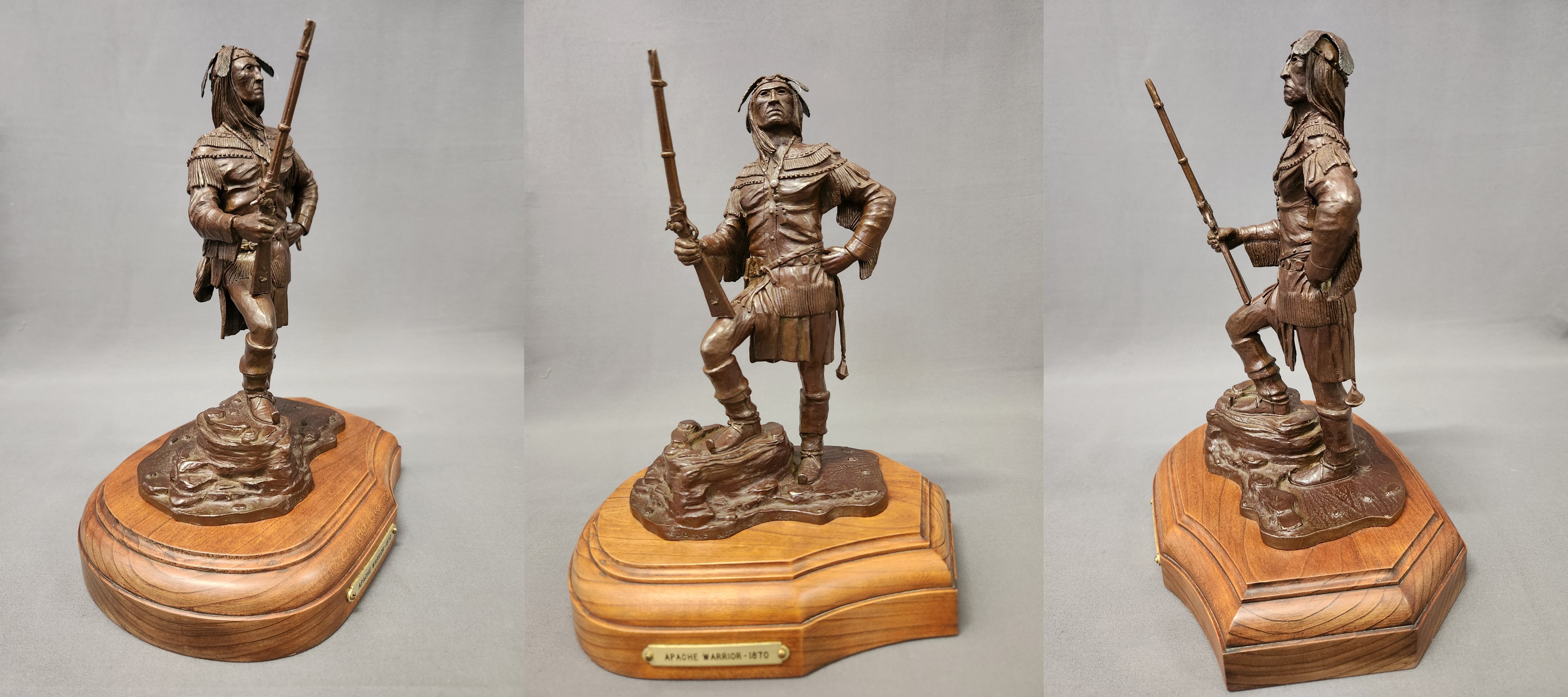 Bronze.  Apache man, standing, weight resting on left leg, right knee bent and foot on rock; holds Sharps rifle in right hand, rifle butt resting on right thigh; left arm bent with hand on hip.