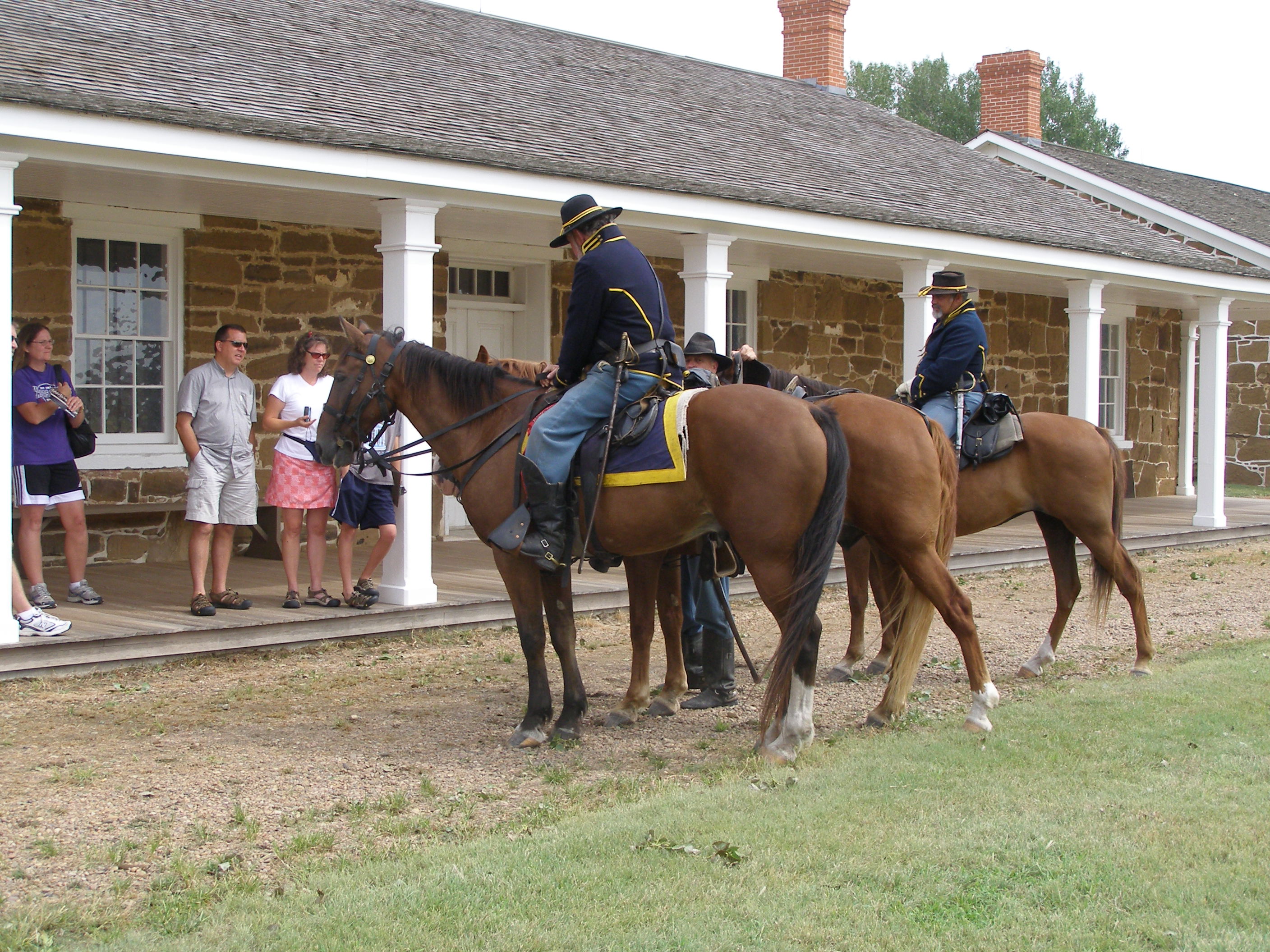 Re-enactors on horses talk to visitors in front of the Visitor Center