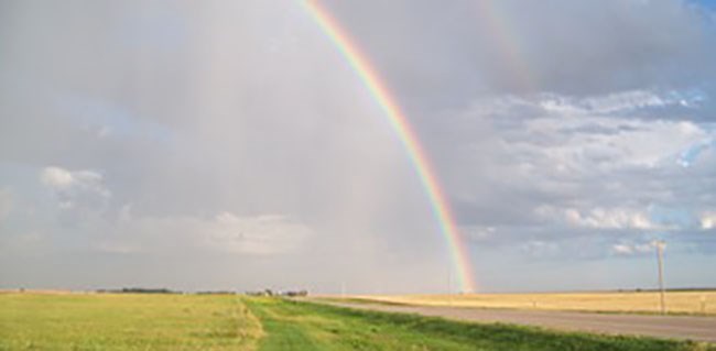 Rainbow over rural Kansas road.