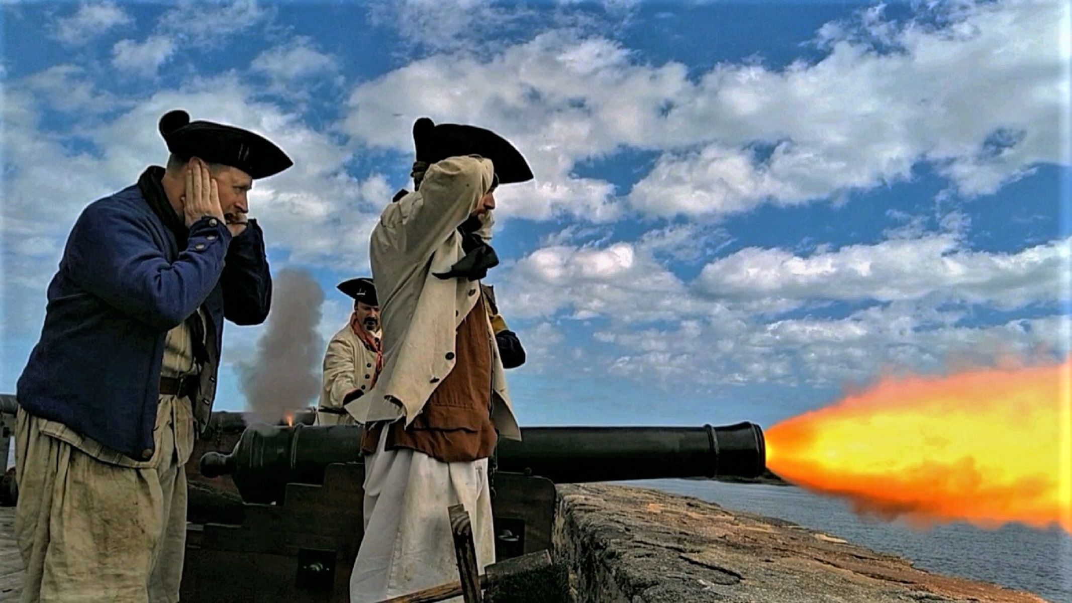 Side view of re-enactors firing cannon