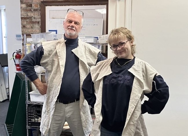 Two people wearing newly sewn revolutionary war hunting vests over modern clothing