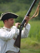 Soldier in tri-corn hat loading a flintlock musket