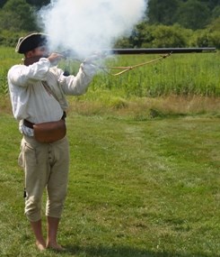 Re-enactor firing a flintlock musket