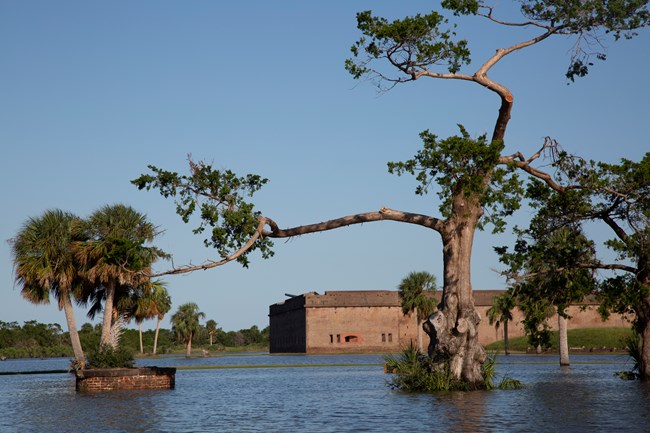 Grassy field is completely flooded, and the fort is in the background.