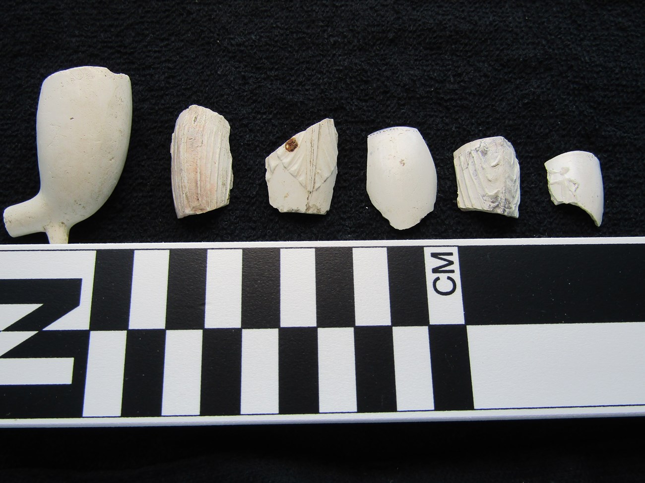 white ceramic pipe bowl fragments on a black background