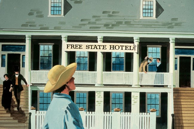 two story building with people gathered around with sign that says Free State Hotel