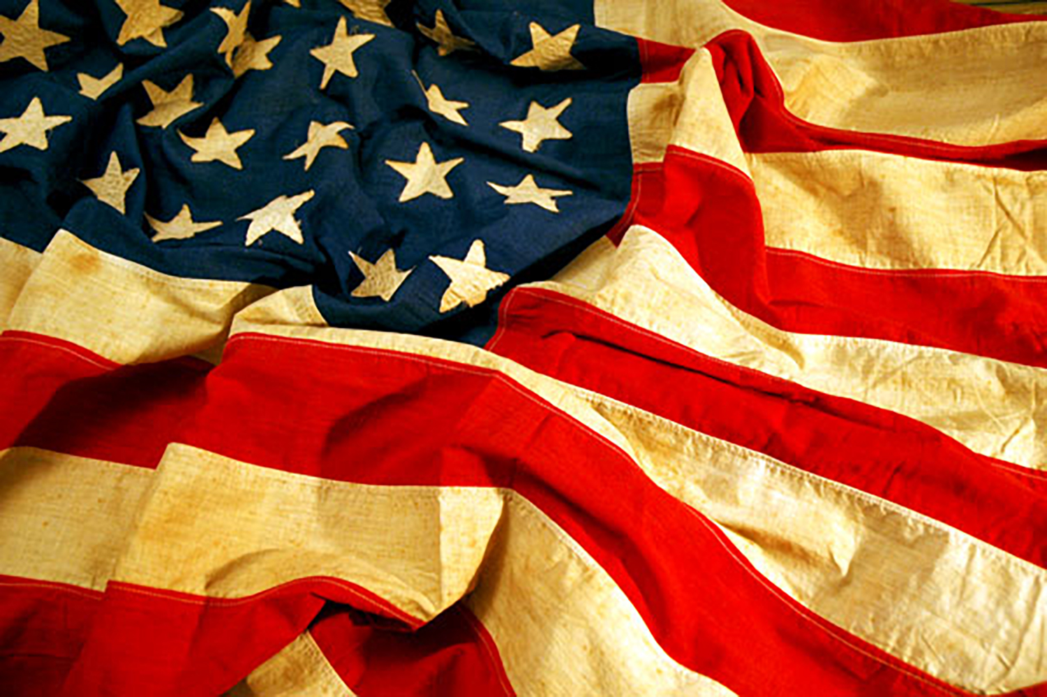 Picture of a older and worn American flag with wrinkles.