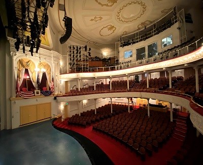 Ford's Theatre Interior, view from stage right, with seating on the floor and two balconies, and the decorated presidential box just opposite.