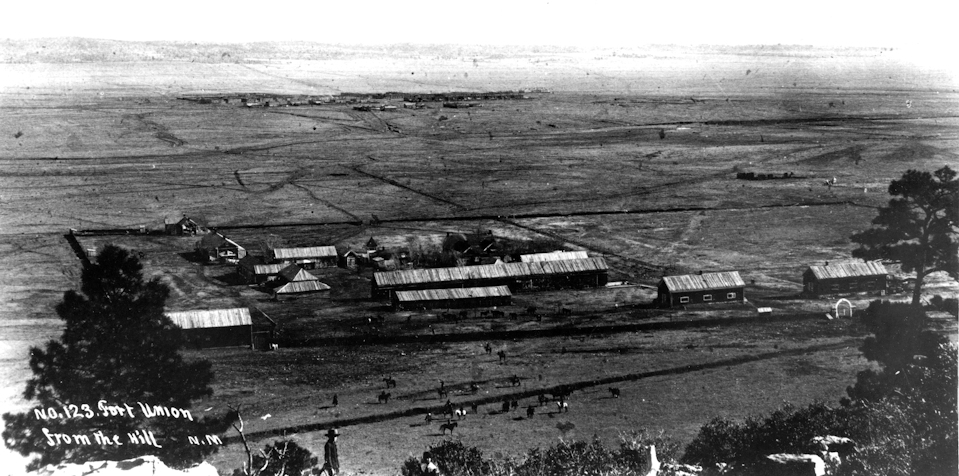cluster of about 16 large buildings in broad, grassy valley