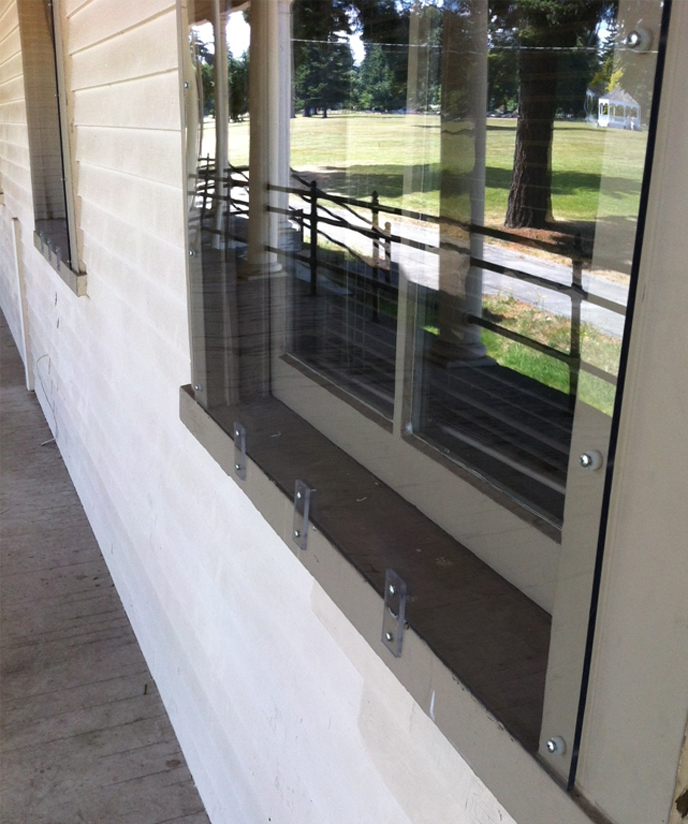 Photo of a historic window at Vancouver Barracks with a temporary plexiglass cover for safety and security