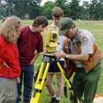 Archaeologist instructing students in the operation of surveyorr's equipment