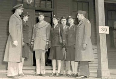 Photo of Military Men and Women standing on the porch of the Women's Army Corps barracks
