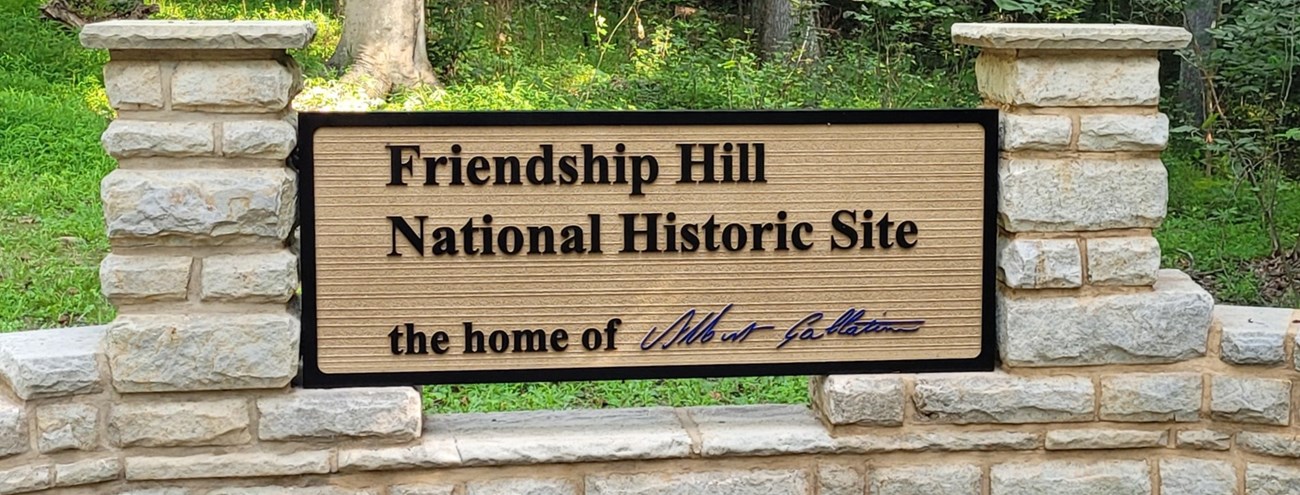 Entrance sign reading Friendship Hill National Historic Site with Albert Gallatin's signature in blue at the bottom