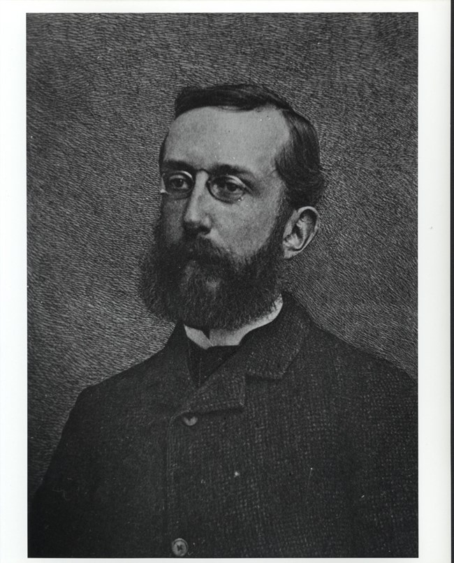 Black and white portrait of white man in his 30s with a beard, Charles Eliot