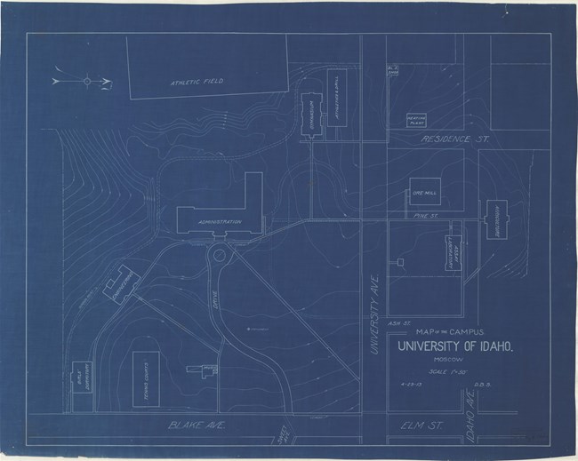White lines on blue paper of rectangular college plan with topographical lines and roads leading around buildings.